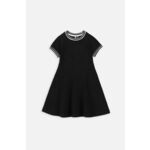 Otroška bombažna obleka Coccodrillo črna barva - črna. Obleka iz kolekcije Coccodrillo. Model izdelan iz enobarvne pletenine. Model je izdelan iz česanega bombaža, zato ga odlikujeta mehak lesk in večja vzdržljivost.