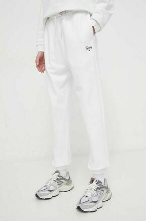 Bombažen spodnji del trenirke Tommy Jeans bela barva - bela. Spodnji del trenirke iz kolekcije Tommy Jeans. Model izdelan iz enobarvne pletenine. Model iz izjemno udobne tkanine z visoko vsebnostjo bombaža.